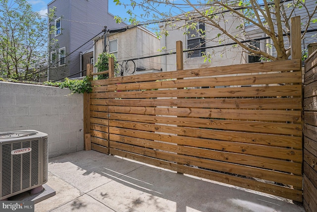 view of patio with central air condition unit and fence