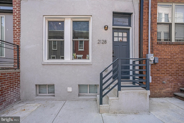 doorway to property featuring stucco siding