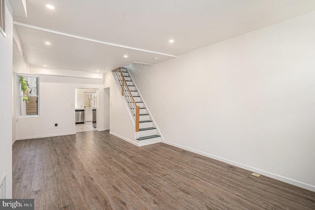 unfurnished living room featuring recessed lighting, baseboards, stairs, and wood finished floors