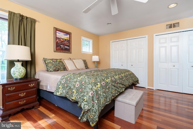 bedroom featuring wood finished floors, a ceiling fan, two closets, visible vents, and recessed lighting