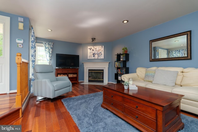 living area with recessed lighting, baseboards, a fireplace with flush hearth, and dark wood-style floors