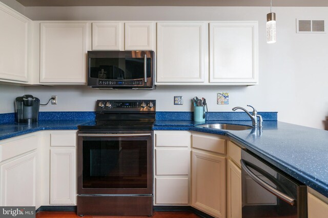 kitchen with a sink, stainless steel appliances, visible vents, and white cabinets