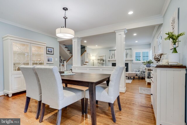 3207 19th St N, Arlington, VA 22201 - dining room featuring ornate columns, a fireplace, light wood-style flooring, stairway, and crown molding