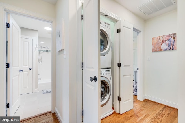 3207 19th St N, Arlington, VA 22201 - laundry room with stacked washer / drying machine, light wood-type flooring, and baseboards