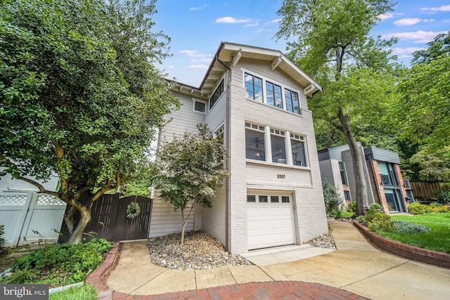 3207 19th St N, Arlington, VA 22201 - view of front of home with fence, a garage, concrete driveway, and brick siding