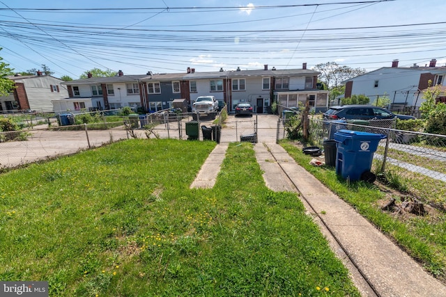 view of front facade featuring a residential view, fence private yard, and a front lawn