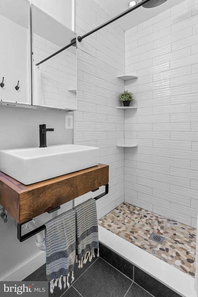 3416 Rustic Way Ln, Falls Church, VA 22044 - bathroom featuring tiled shower, a sink, tile patterned flooring, and baseboards