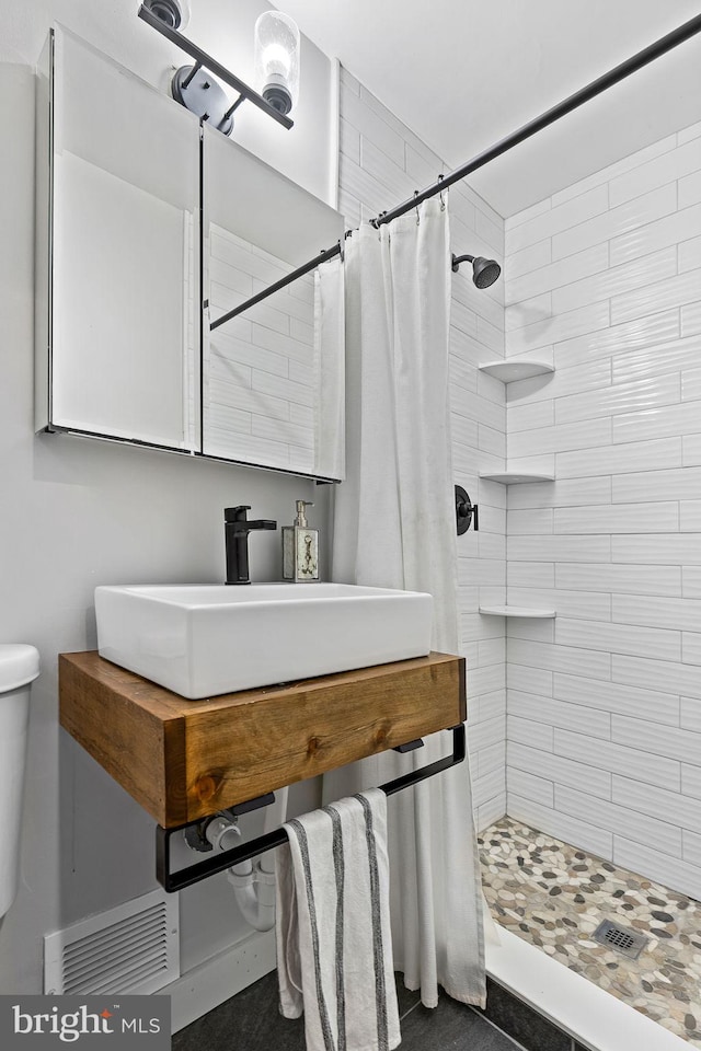 3416 Rustic Way Ln, Falls Church, VA 22044 - bathroom featuring a tile shower, a sink, and toilet