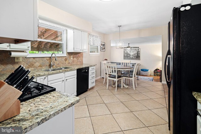 kitchen featuring decorative backsplash, light tile patterned flooring, white cabinetry, a sink, and black appliances