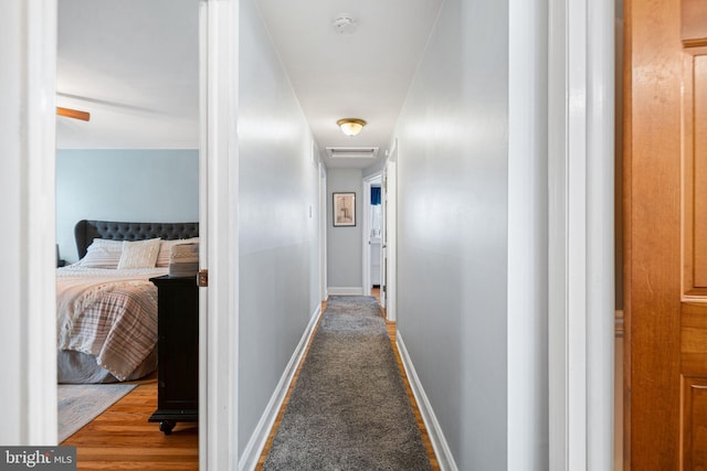corridor with baseboards and visible vents