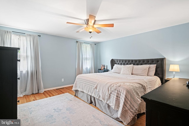 bedroom with baseboards, ceiling fan, and wood finished floors