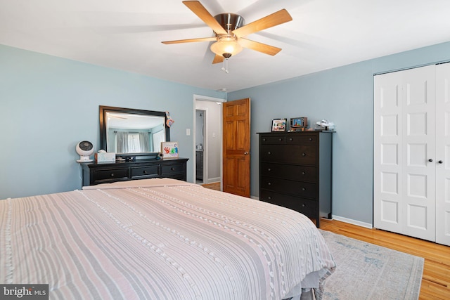bedroom with a closet, a ceiling fan, baseboards, and wood finished floors