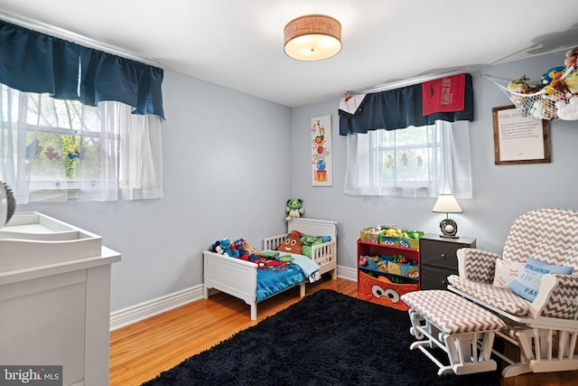 bedroom featuring baseboards and wood finished floors