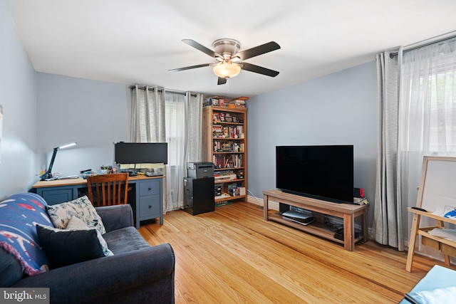 living area featuring light wood finished floors and ceiling fan