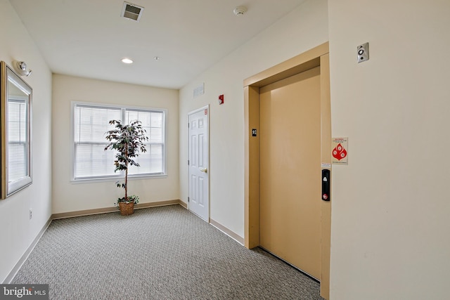 corridor featuring carpet floors, visible vents, baseboards, elevator, and recessed lighting