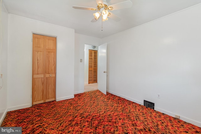 unfurnished bedroom with carpet floors, a ceiling fan, baseboards, and visible vents
