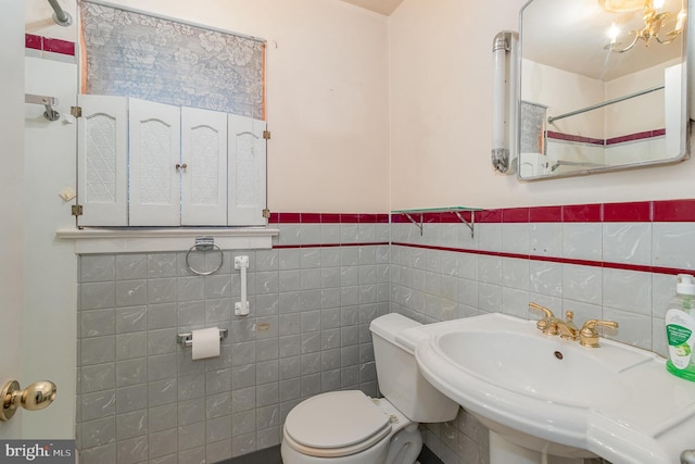 full bath with curtained shower, toilet, tile walls, a wainscoted wall, and a sink