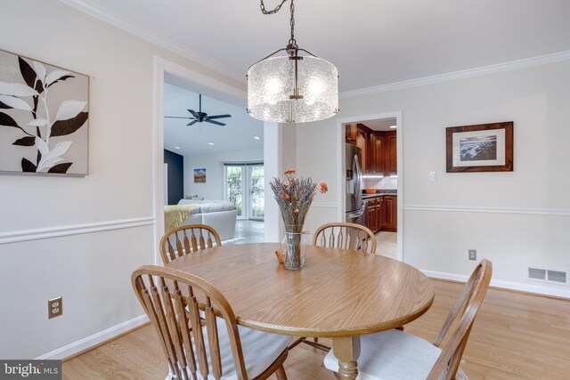 dining area featuring light wood finished floors, baseboards, ornamental molding, and ceiling fan