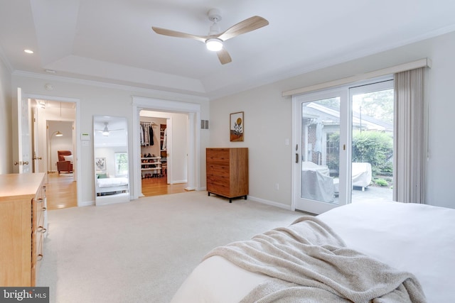 bedroom with access to exterior, a raised ceiling, crown molding, and multiple windows