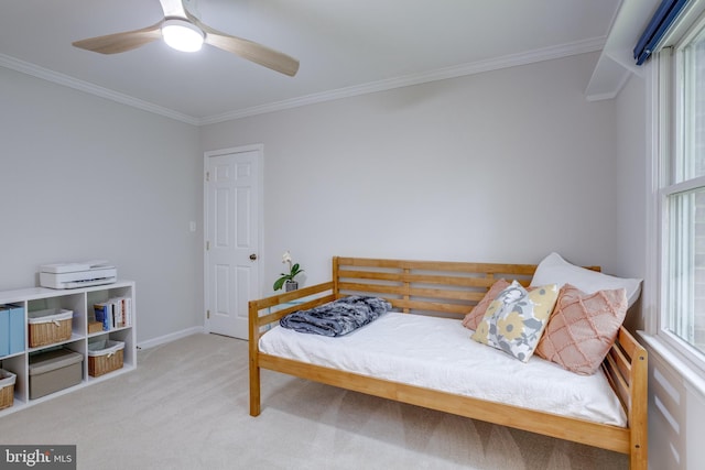 carpeted bedroom featuring crown molding, ceiling fan, and baseboards