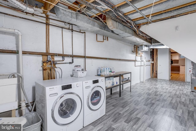 laundry room featuring washer and clothes dryer and wood finished floors
