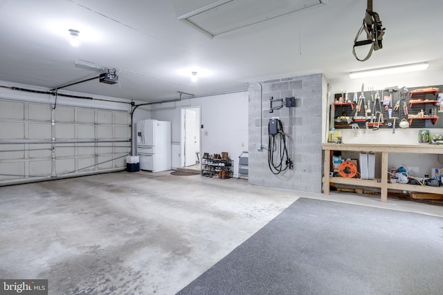 garage featuring freestanding refrigerator and a garage door opener