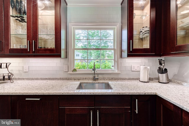 1109 Neal Dr, Alexandria, VA 22308 - kitchen featuring a sink, ornamental molding, dark brown cabinets, light stone counters, and backsplash