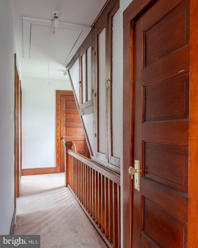 corridor featuring carpet flooring and baseboards