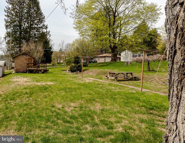 view of yard featuring a wooden deck and an outdoor structure