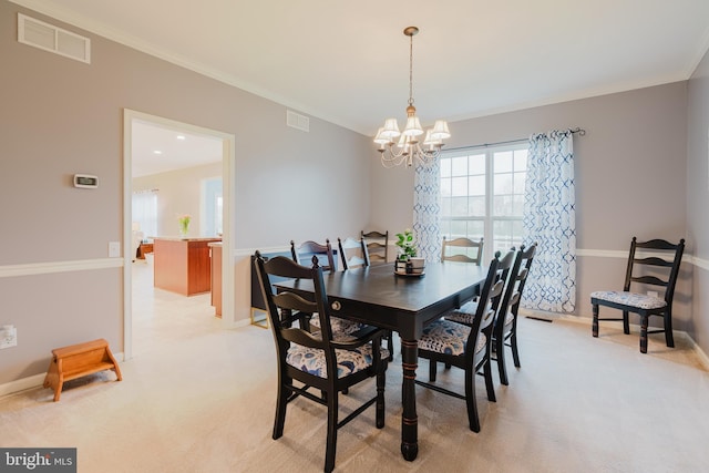dining space with a notable chandelier, visible vents, ornamental molding, and light carpet