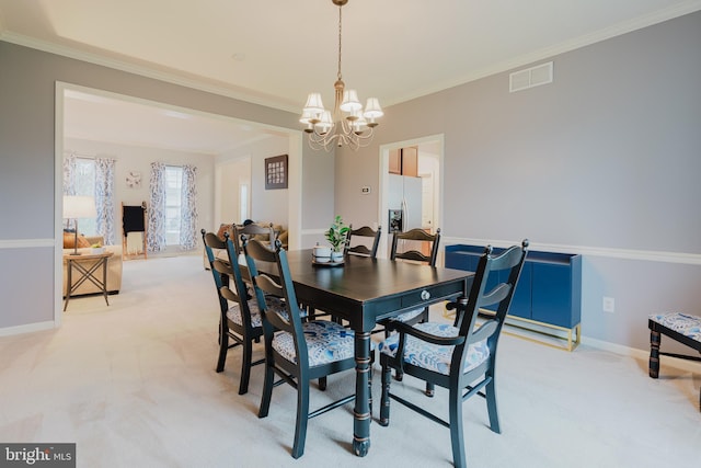 dining room featuring crown molding, light colored carpet, visible vents, and an inviting chandelier