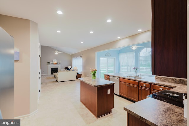 kitchen with a sink, ceiling fan, vaulted ceiling, and dishwashing machine