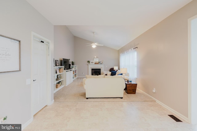living area with ceiling fan, visible vents, a fireplace, baseboards, and lofted ceiling