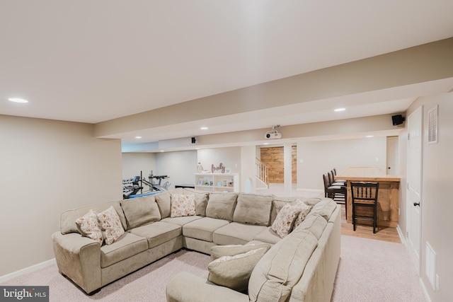 living area featuring baseboards, light carpet, recessed lighting, and wet bar