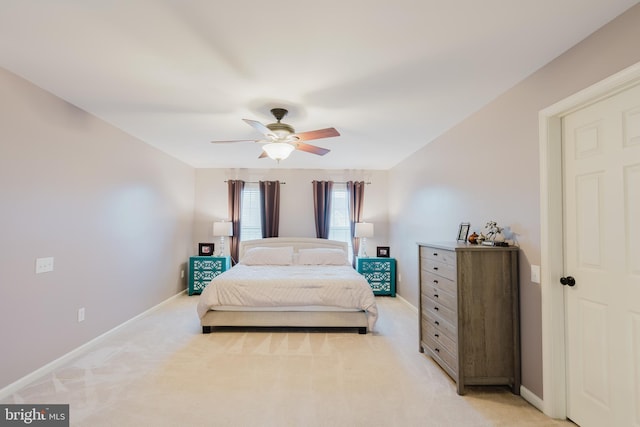 bedroom featuring baseboards, light colored carpet, and ceiling fan