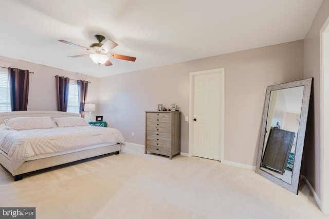 bedroom with baseboards, a ceiling fan, and light colored carpet