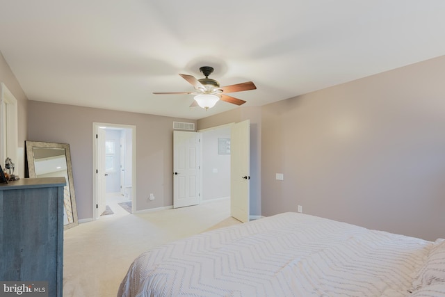 bedroom featuring ceiling fan, light carpet, ensuite bath, baseboards, and visible vents