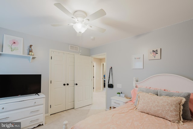 bedroom featuring visible vents, a ceiling fan, a closet, and light colored carpet