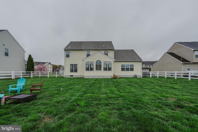 rear view of property with a fenced backyard, a lawn, and crawl space