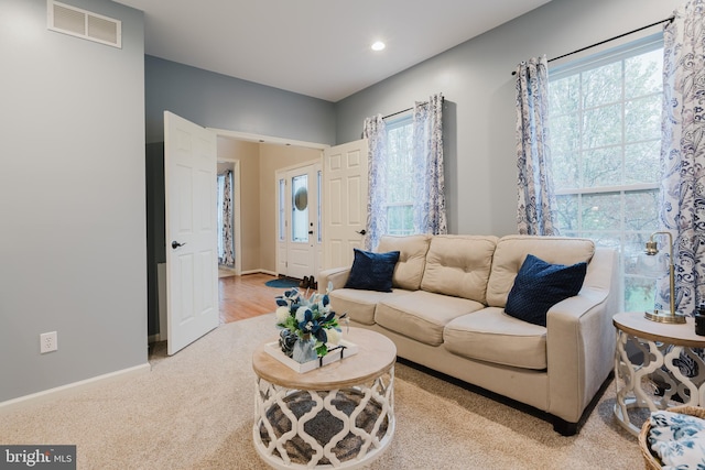 living area featuring recessed lighting, baseboards, visible vents, and light carpet