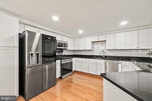 1521 N Van Dorn St, Alexandria, VA 22304 - kitchen with stainless steel appliances, a sink, light wood finished floors, dark countertops, and recessed lighting