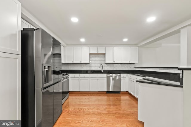 1521 N Van Dorn St, Alexandria, VA 22304 - kitchen with appliances with stainless steel finishes, a sink, dark countertops, white cabinets, and recessed lighting