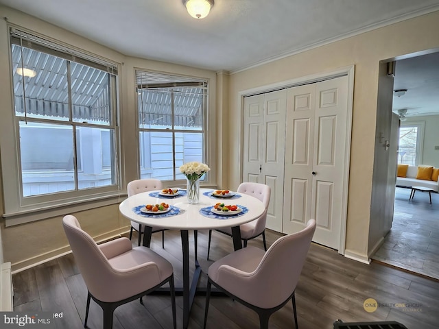 dining room with baseboards, ornamental molding, and dark wood finished floors