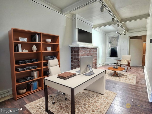office space featuring track lighting, beam ceiling, a fireplace, baseboards, and dark wood-style floors