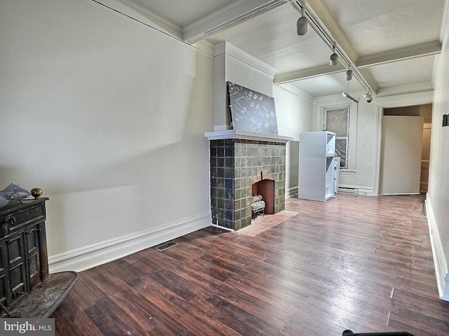 unfurnished living room with baseboards, ornamental molding, a tiled fireplace, and wood finished floors