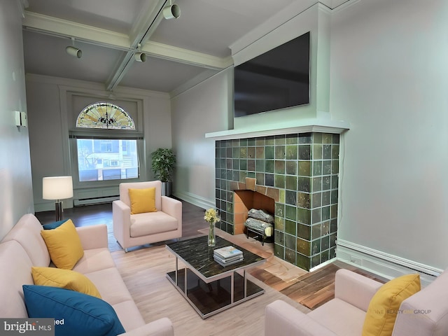 living area featuring wood finished floors, a fireplace, beamed ceiling, a baseboard radiator, and coffered ceiling