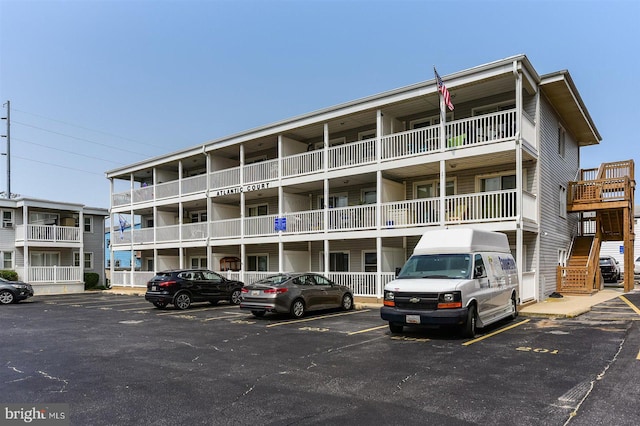 view of property with uncovered parking and stairway