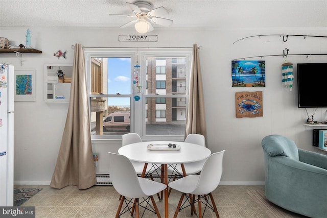 dining room featuring a textured ceiling, baseboards, a ceiling fan, and tile patterned floors