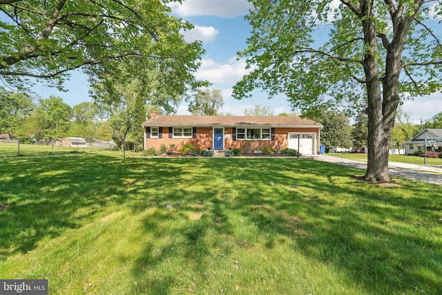 ranch-style home featuring a chimney, driveway, fence, a garage, and a front lawn