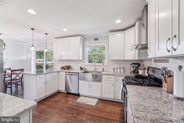 kitchen featuring a sink, a peninsula, white cabinetry, and appliances with stainless steel finishes